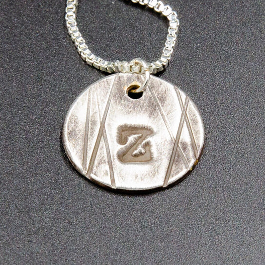 A pure silver pendant stamped with the initial or name of your choice.