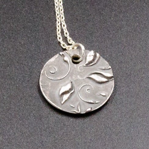 A pure silver pendant stamped with the initial or name of your choice.